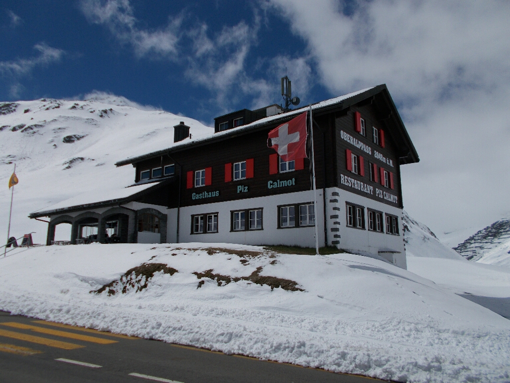 Swiss styled restaurant at the summit of Oberalp pass, surrounded by white snow.