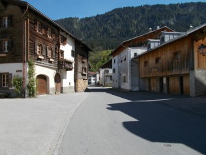 A small lane through the Swiss village of Castrisch. Buildings on either side.