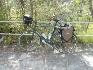 A Surly Disc Trucker fully loaded for touring, leaning against a metal fence.