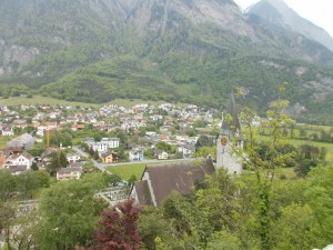 Houses, with an old church in the foreground, taken from an elevated location.