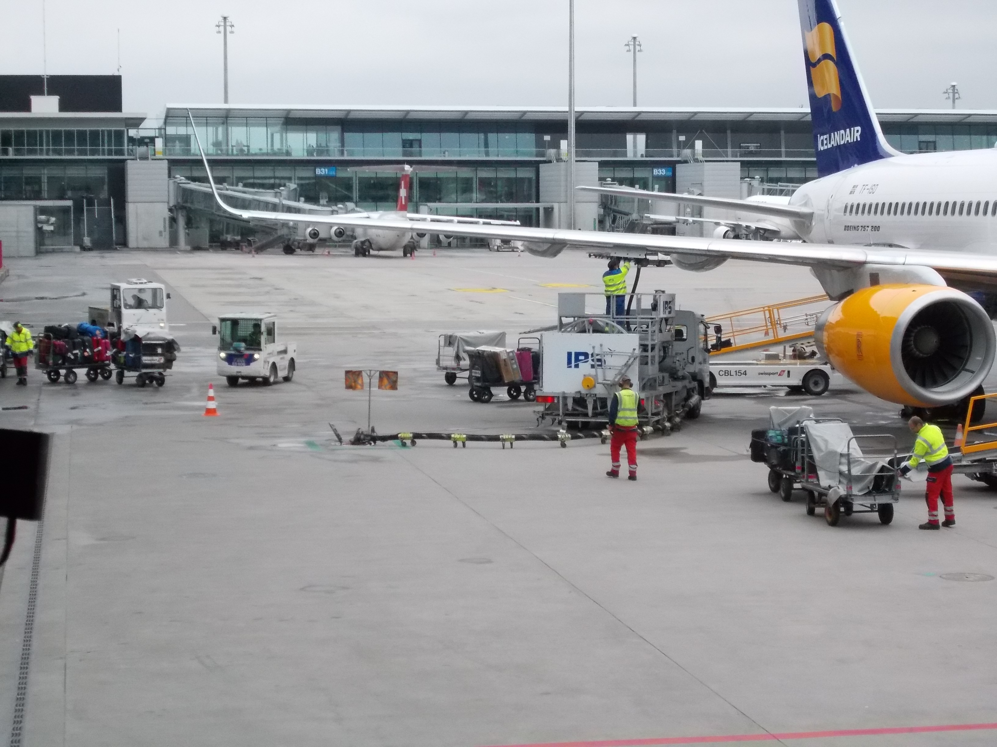 Icelandair aircraft with bike boxes being unloaded down cargo ramp.