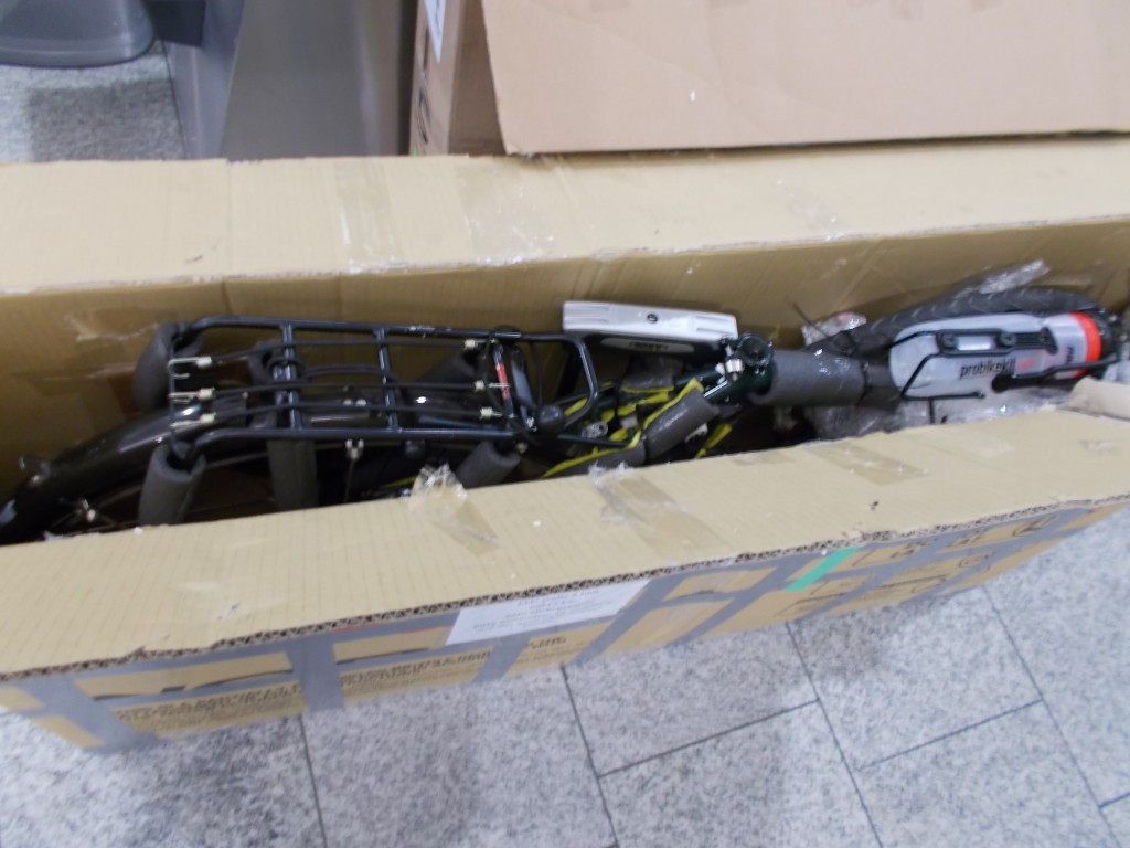 A Surly Disc Trucker disassembled and in a bike box on the floor of the Zürich airport.