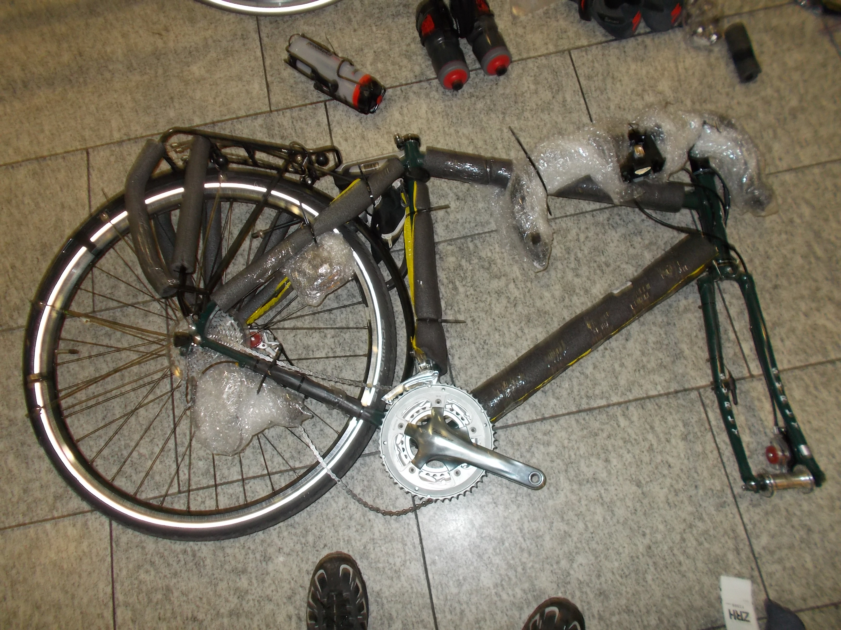A Surly Disc Trucker bike (green) ready for reassembly on the floor of the Zürich airport.