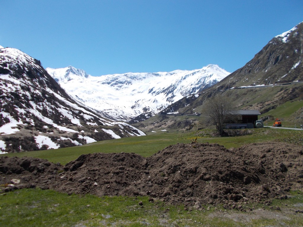 Snow capped peaks and green valleys looking up the Oberalp pass road.