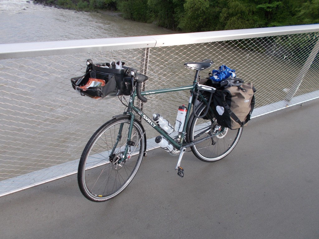 A green Surly Disc Trucker, slightly wet, drying out on a bridge.