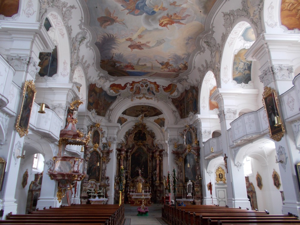 A beautifully painted church interior with a vast painting on the ceiling taken at Münster Unserer Lieben Frau in Lindau, Germany.