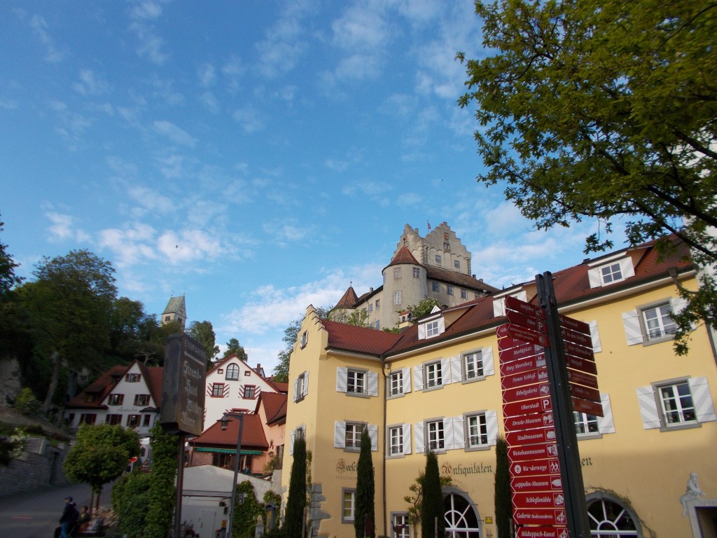 Colorful buildings with a large castle in the background in Meersburg, Germany.