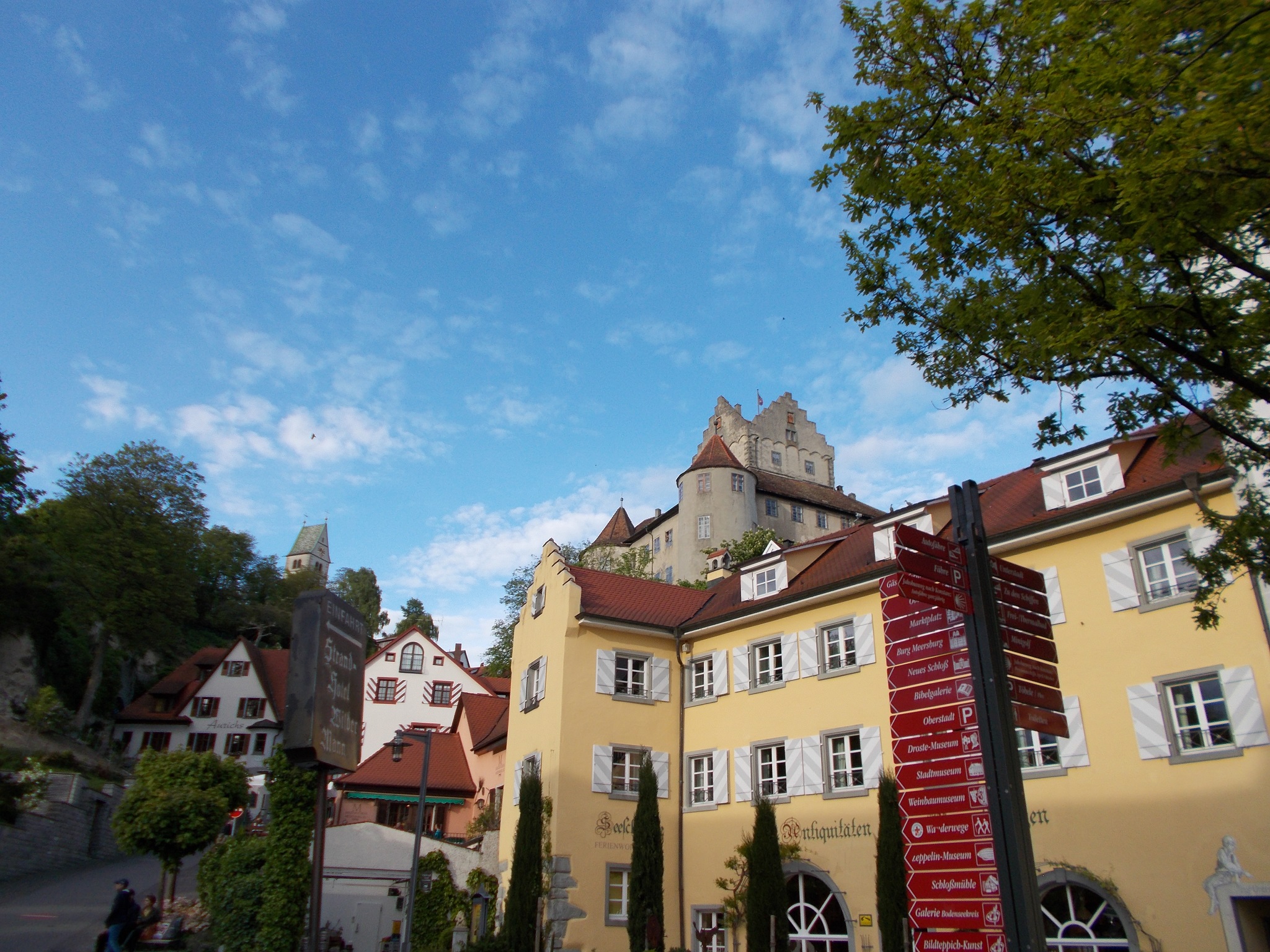 Colorful buildings with a large castle in the background in Meersburg, Germany.