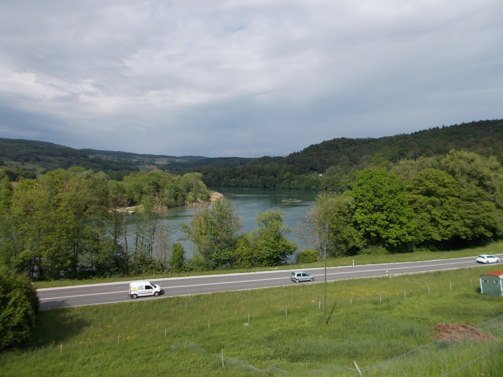 A large river with a river valley in the background.