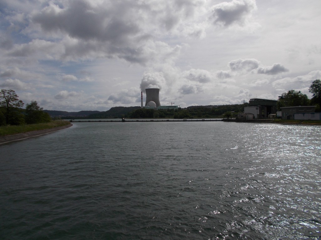 The Rhine river with the cooling tower of a nuclear power plant visible in the distance.