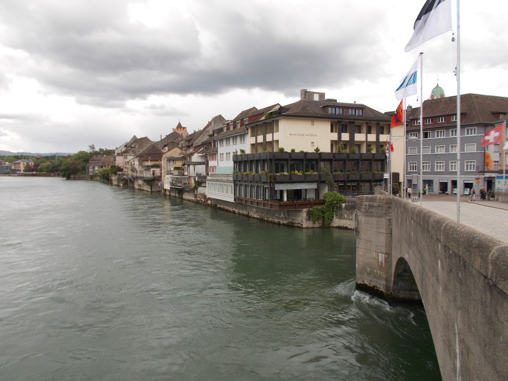 A large river photographed from a bridge with ornate buildings lining the bank.