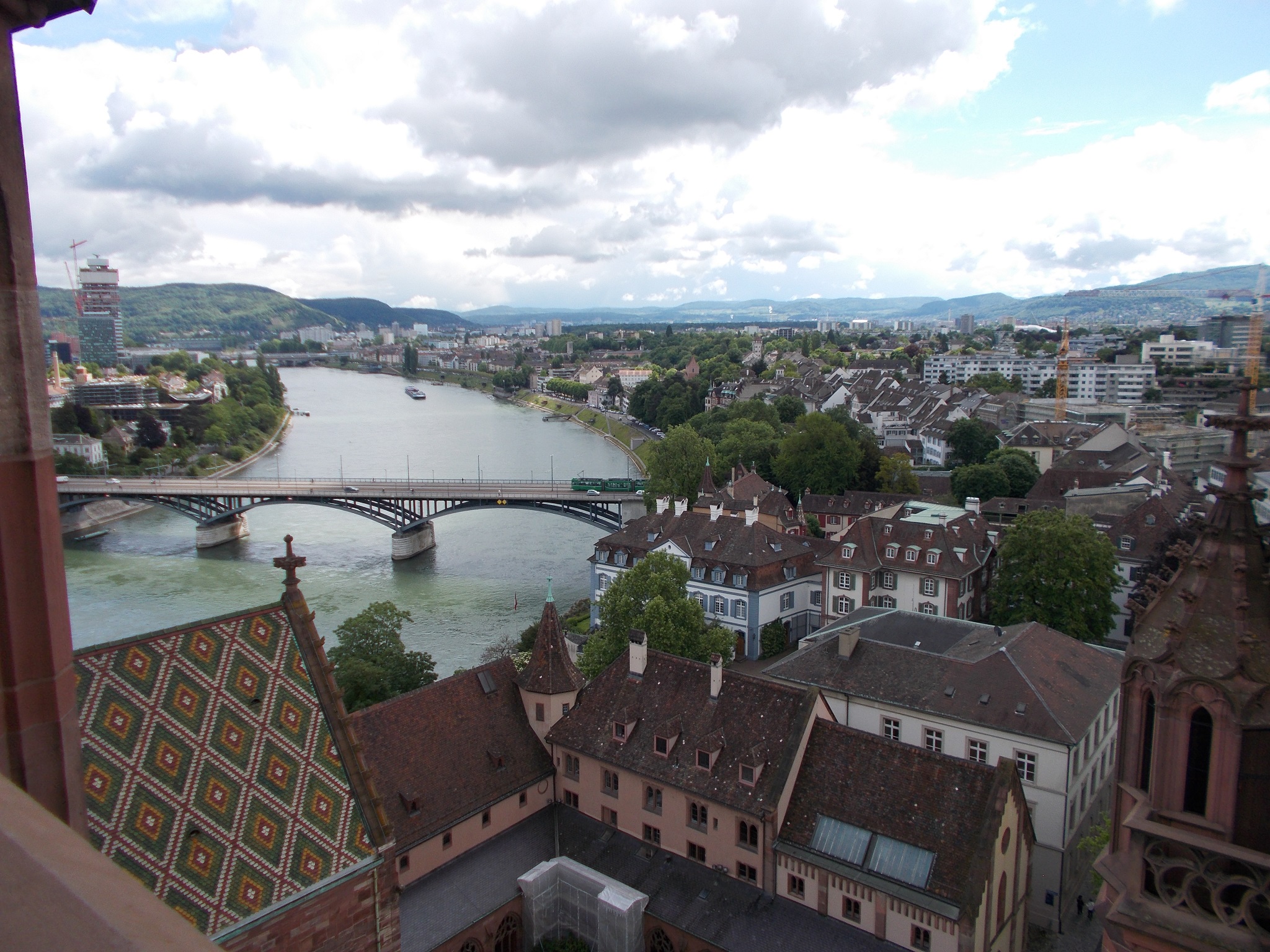 A large river running through Basel, Switzerland, a spire of a cathedral visible in the foreground.
