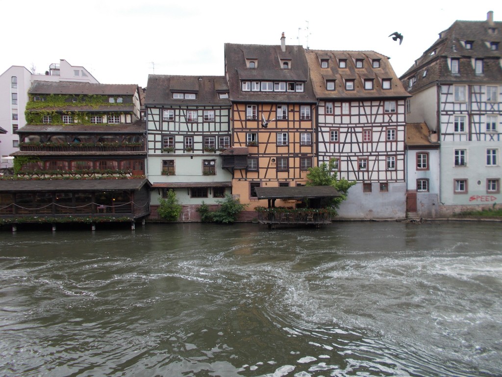 Beautiful French buildings built directly on the waters edge of a waterway running through Strasbourg, France.